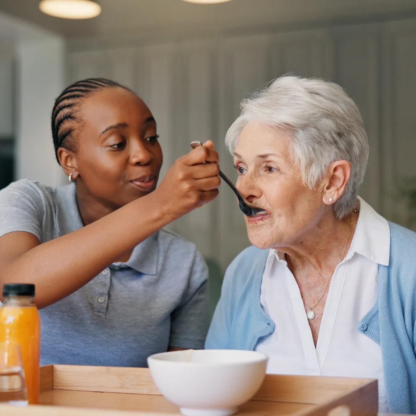 Professional caregiver providing attentive care to a senior while family takes a needed break