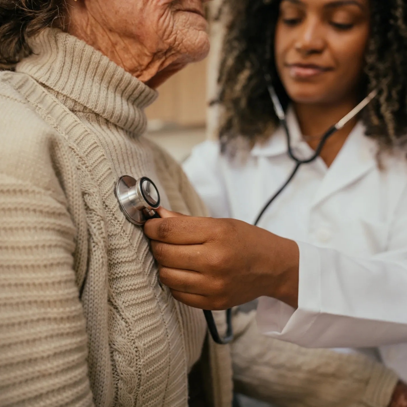 Caregiver providing individualized one-on-one attention to a senior — both faces and hands visible